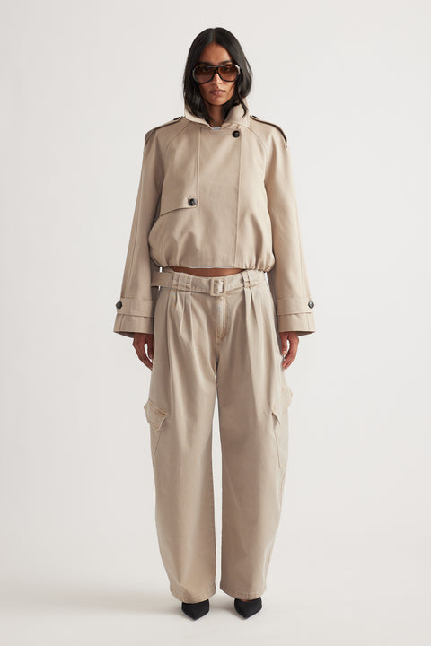 Woman wearing light beige belted balloon cargo pants paired with a matching cropped jacket and black pointed heels