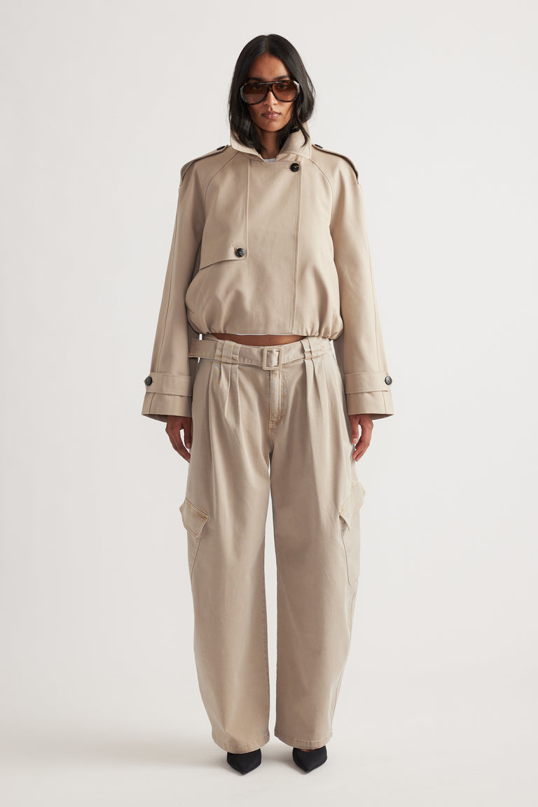 Woman wearing light beige belted balloon cargo pants paired with a matching cropped jacket and black pointed heels