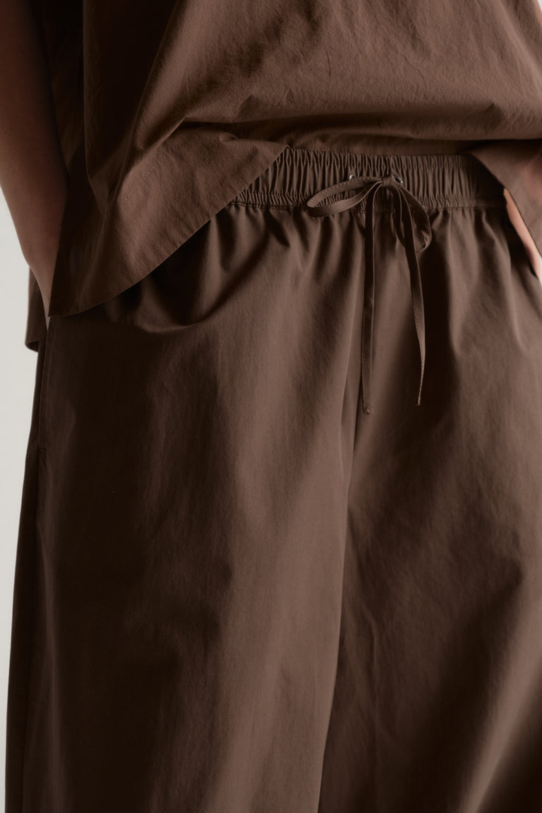 Brown barrel leg pants with an elasticated drawstring waist and relaxed fit