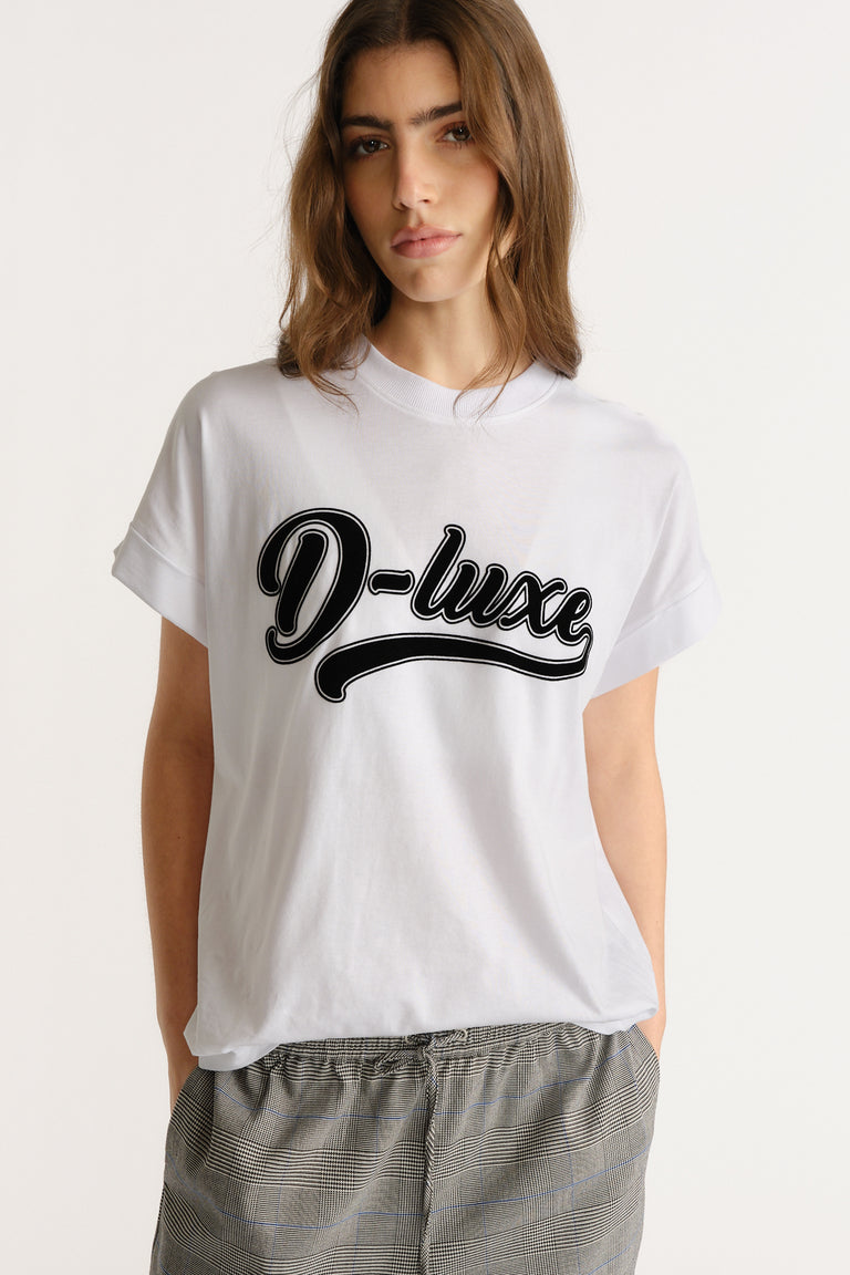 Woman wearing a relaxed white tee with bold script print paired with casual checked trousers for an easy everyday look.