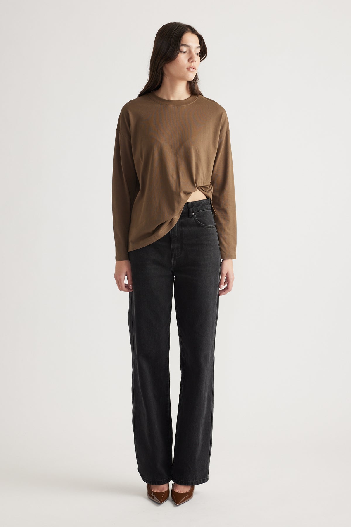 Woman wearing a bronze long sleeve top with black high-waisted wide-leg jeans and brown pointed heels