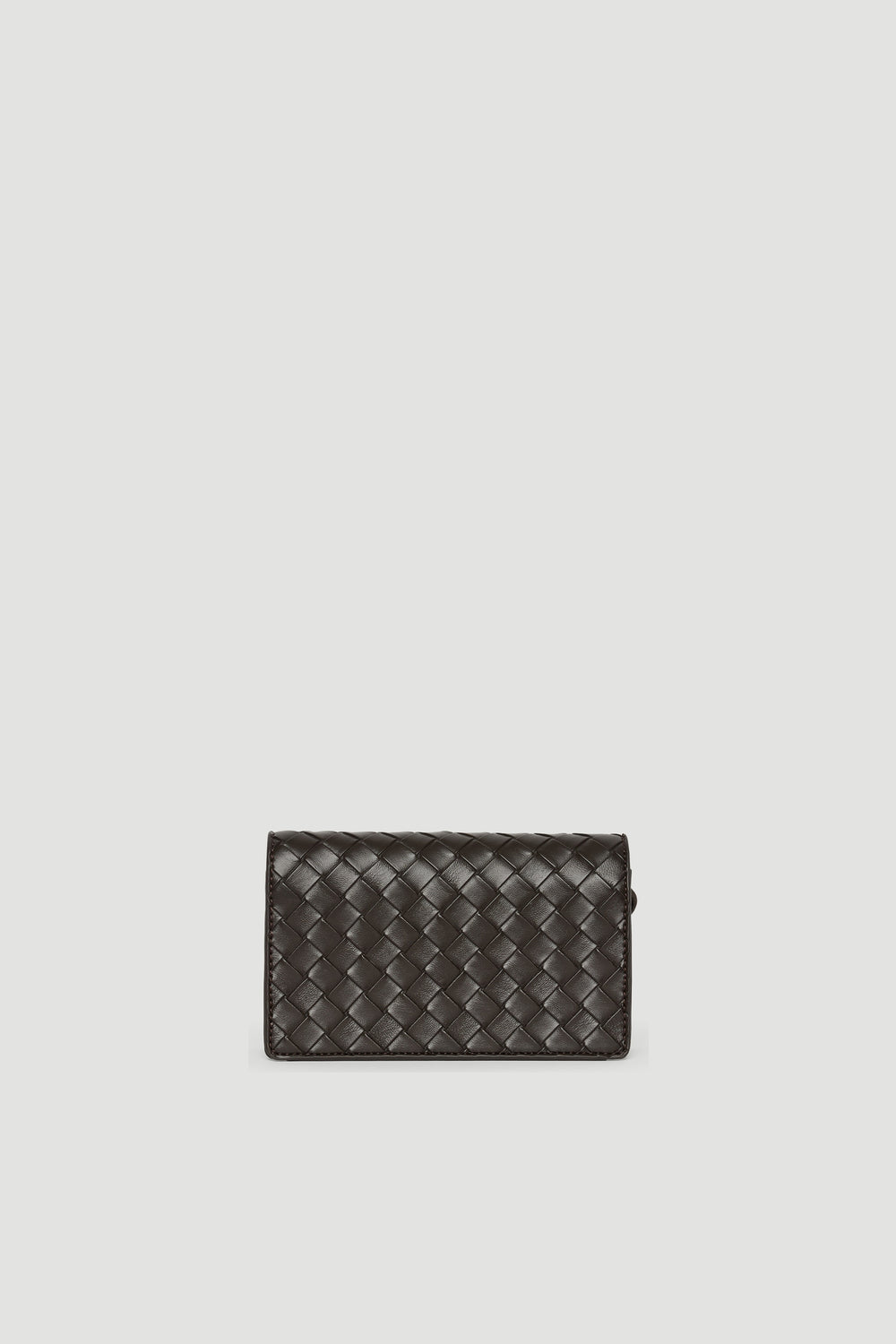 Small dark brown crossbody bag with woven texture and gold-toned clasp closure against pale background
