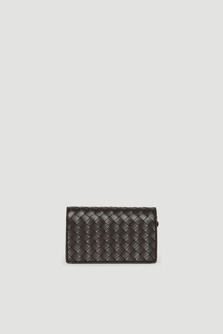 Small dark brown crossbody bag with woven texture and gold-toned clasp closure against pale background