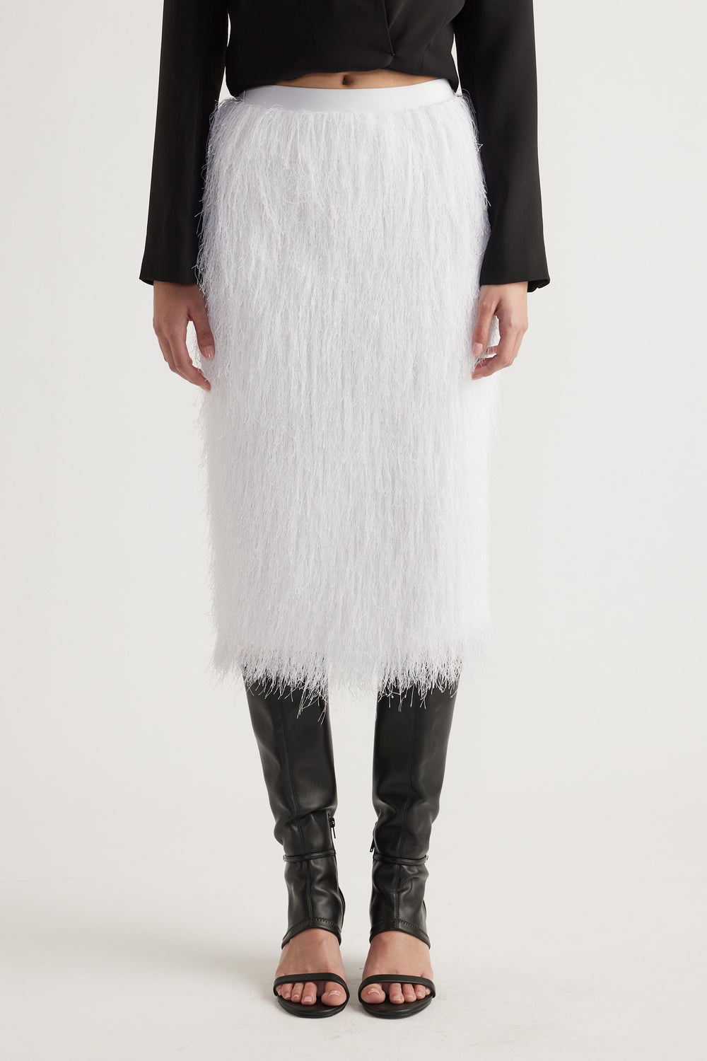 White midi skirt with textured fringe detail styled with black long-sleeve top and knee-high black boots