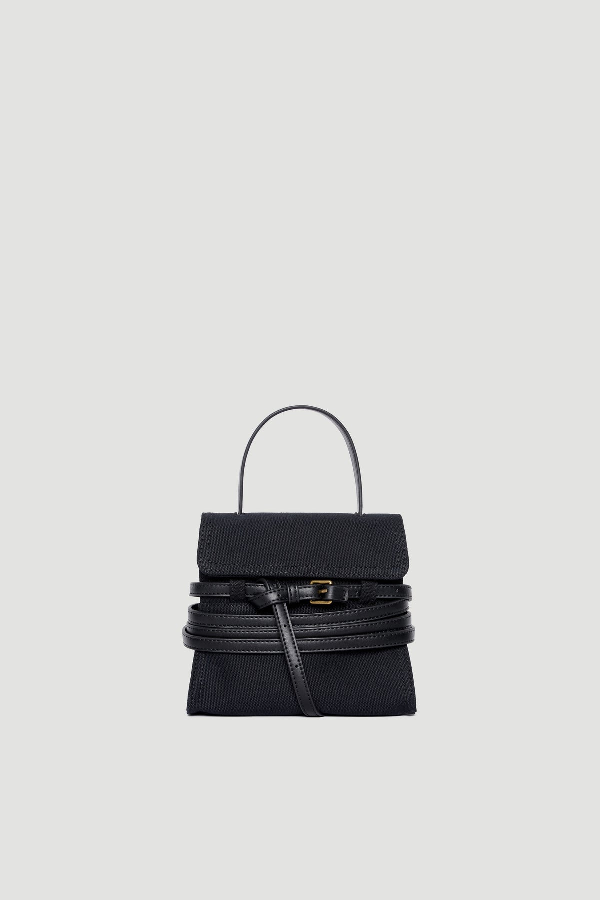 Black structured handbag with leather belt buckle detail and top handle on plain background