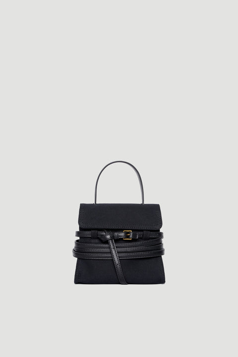 Black structured handbag with leather belt buckle detail and top handle on plain background