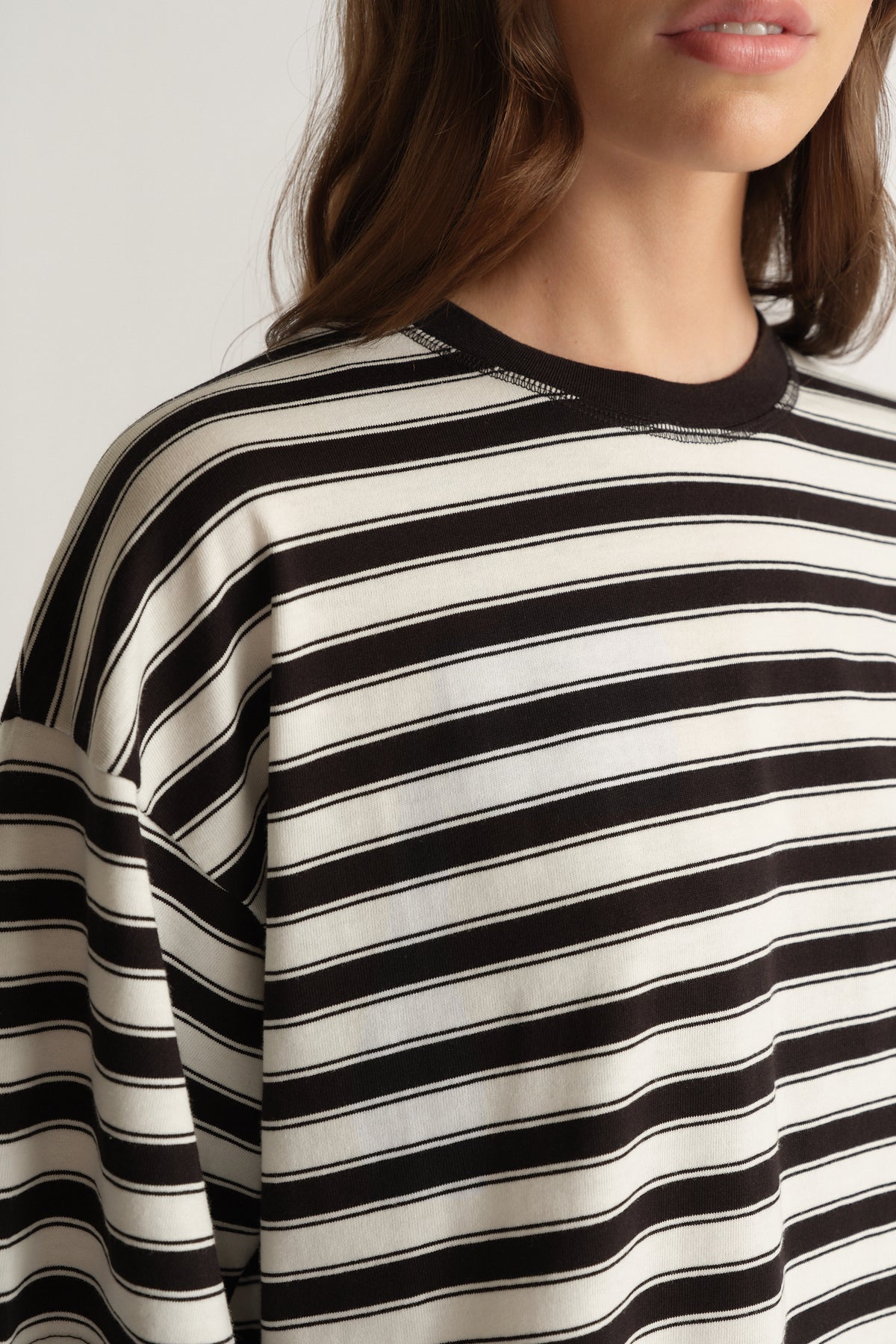 Woman wearing an oversized black and white striped crew neck tee