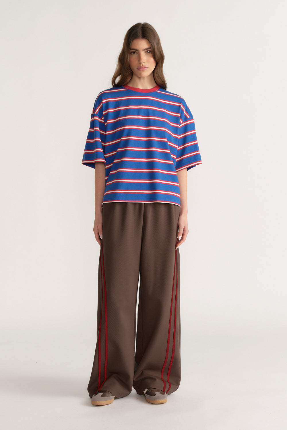 Woman wearing an oversized blue and red striped tee with brown wide-leg pants