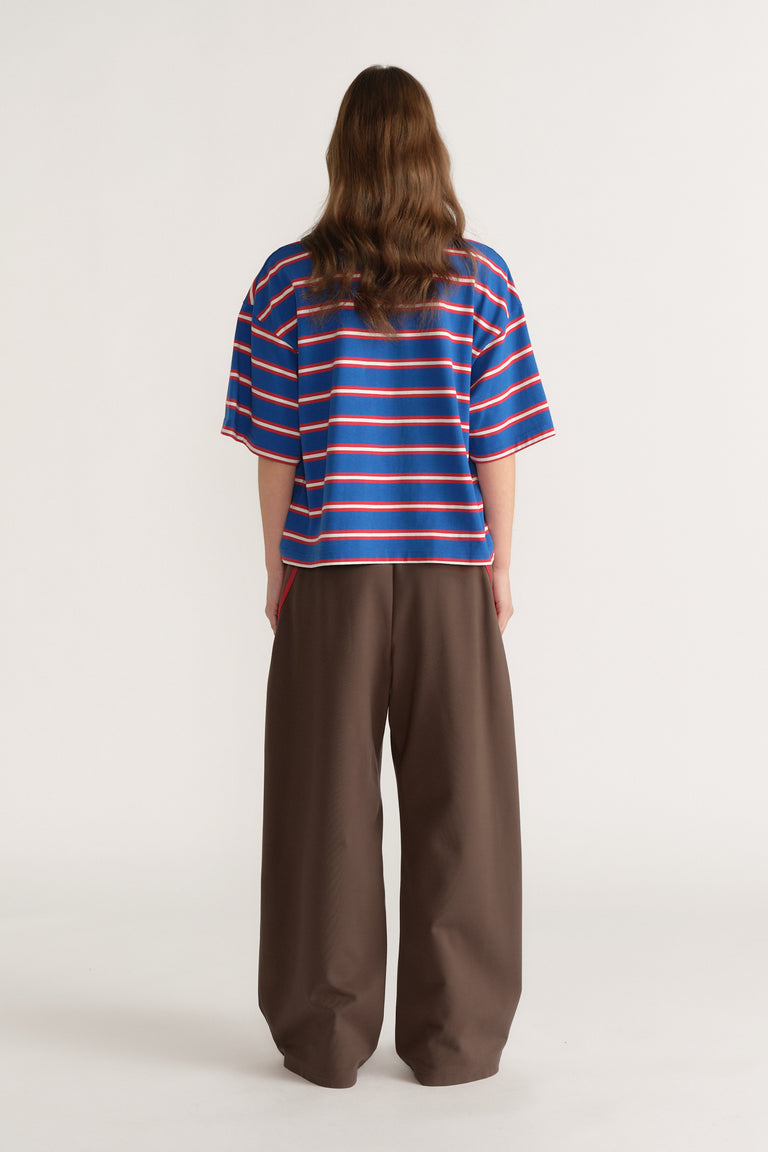 Back view of a woman wearing an oversized blue striped tee with brown wide leg pants