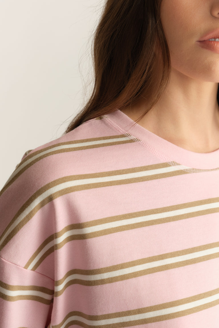 Woman wearing a pink and beige striped crew neck tee with oversized sleeves