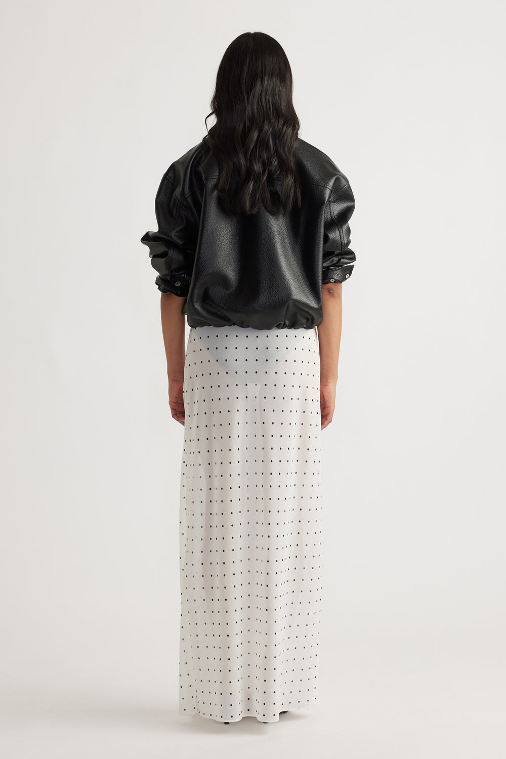 Back view of model wearing Faye Sheer Maxi Skirt with black polka dots in portrait gallery position 3, 1600x2400 size.
