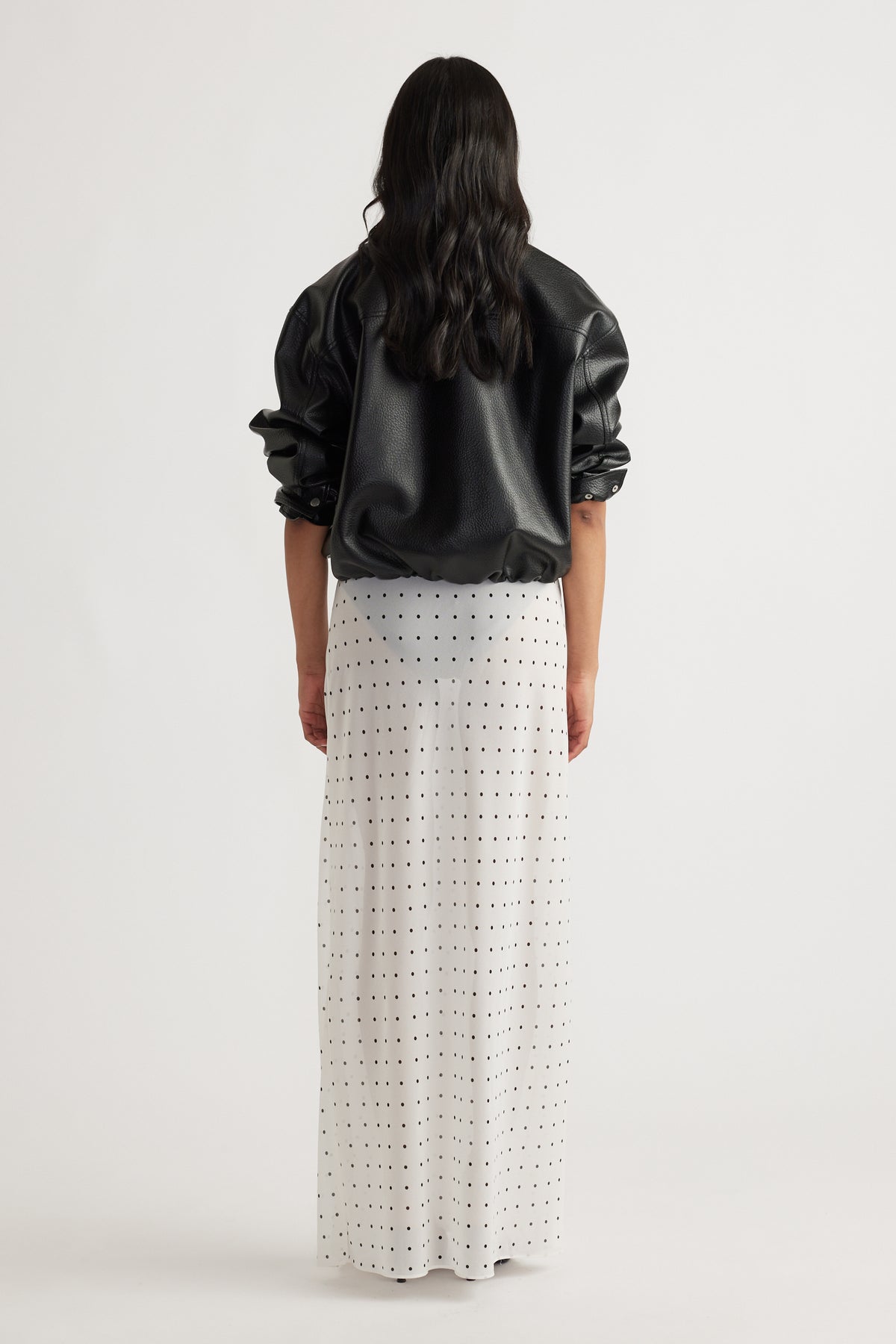 Back view of model wearing Faye Sheer Maxi Skirt with black polka dots in portrait gallery position 3, 1600x2400 size.