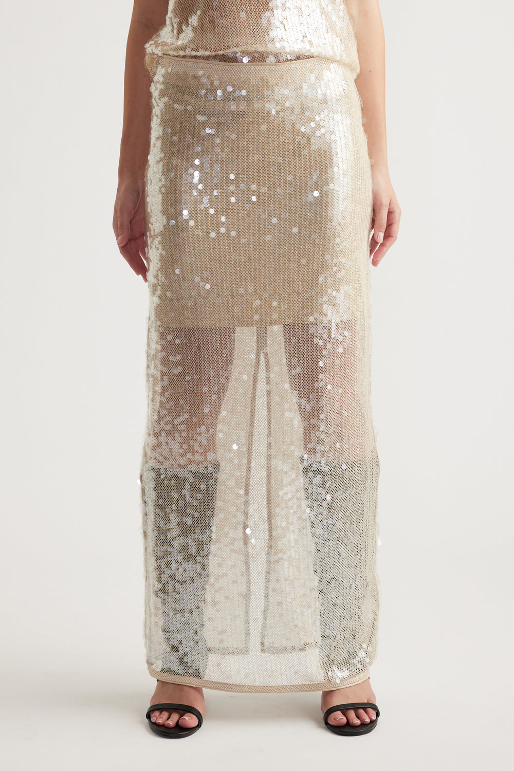 Sheer maxi skirt covered in shimmering champagne sequins, styled for a glamorous and modern look.