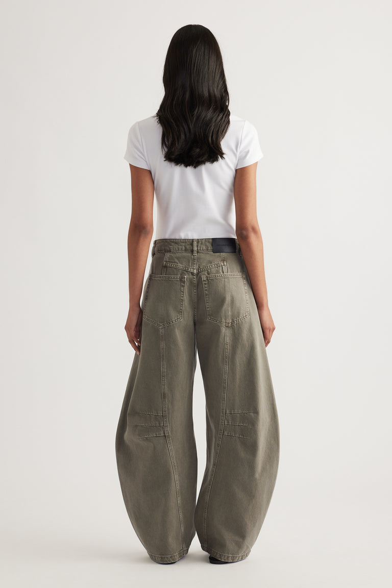 Woman viewed from behind wearing a white tee and high rise grey barrel leg jeans