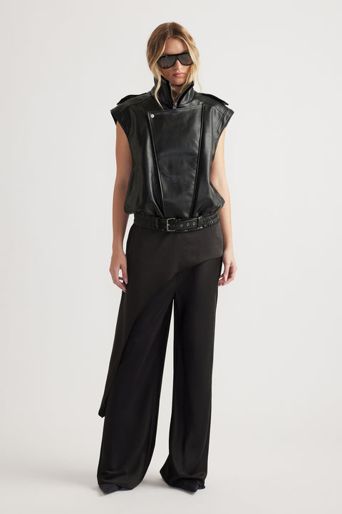 Woman wearing black full-length straight-leg pants with an elastic waist and sleeveless black vest with sunglasses