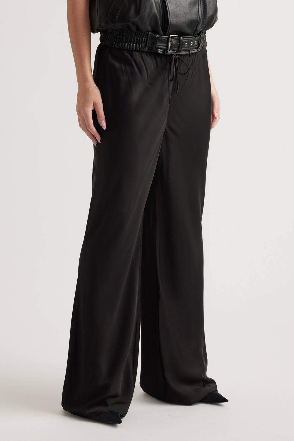 Woman wearing black bias cut pants with an elastic drawcord waist and full length wide legs