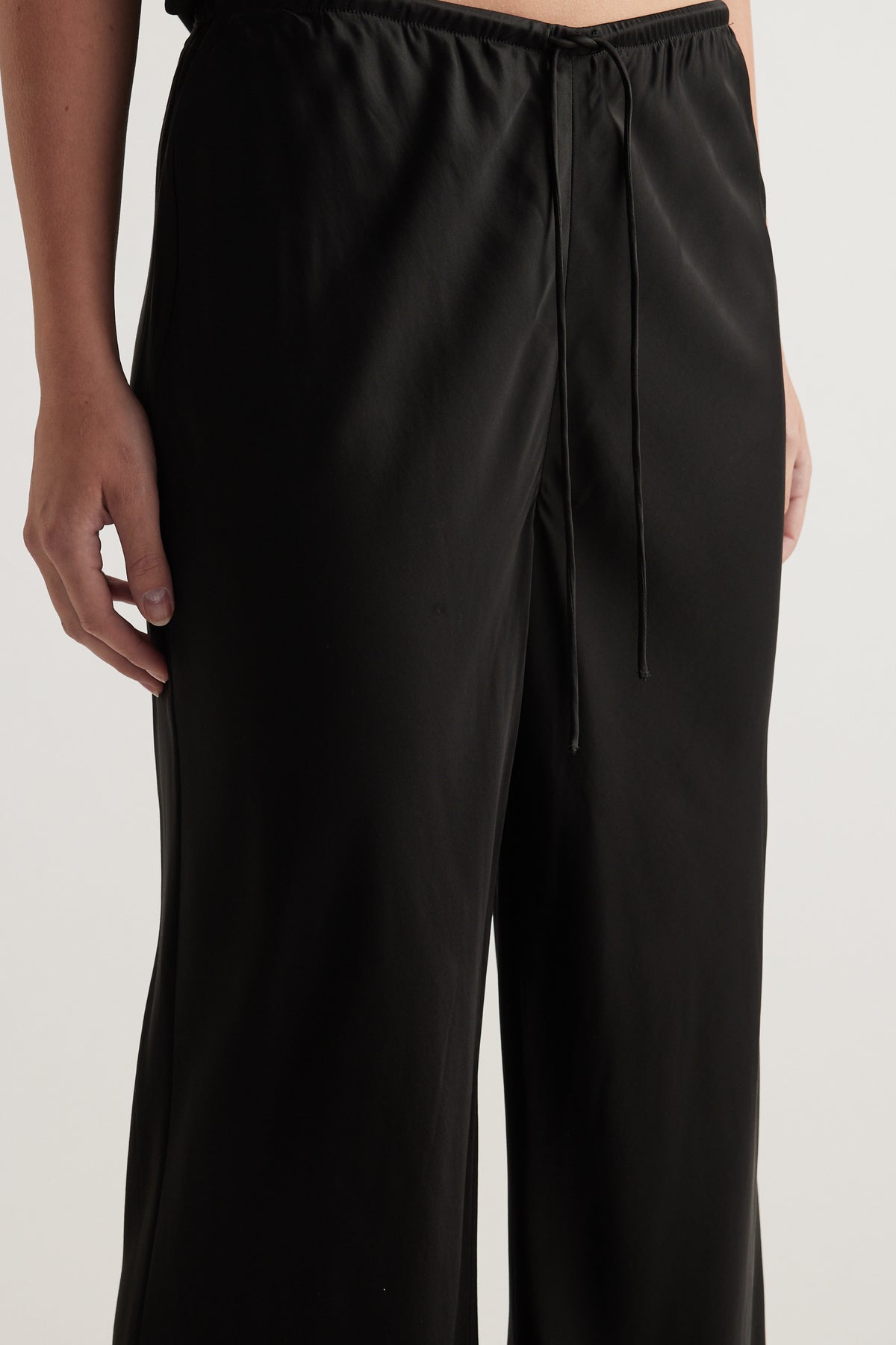 Black bias cut pants with an elastic drawcord waist and full length straight legs