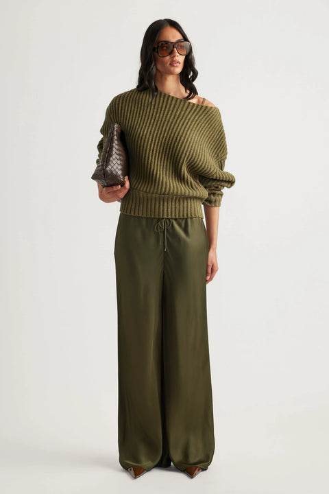 Woman wearing olive wide leg pants with a ribbed off shoulder sweater and sunglasses