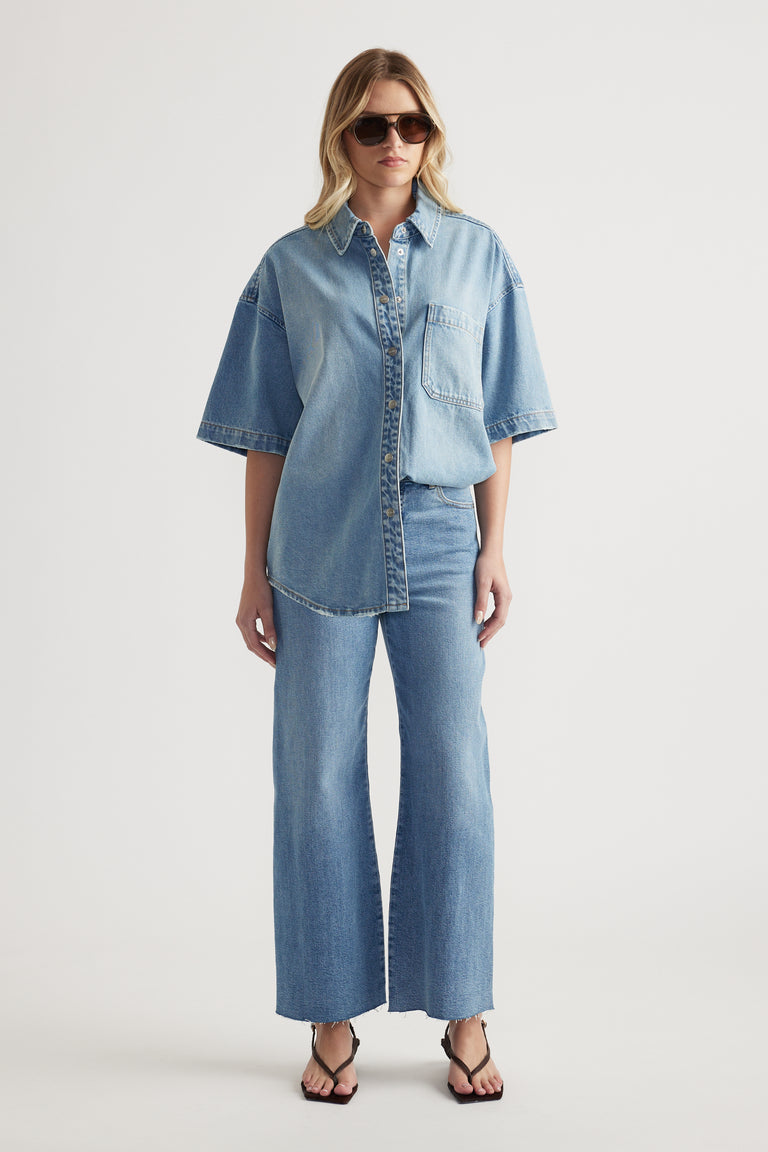 Woman wearing an oversized short sleeve denim shirt with matching wide leg jeans and strappy sandals