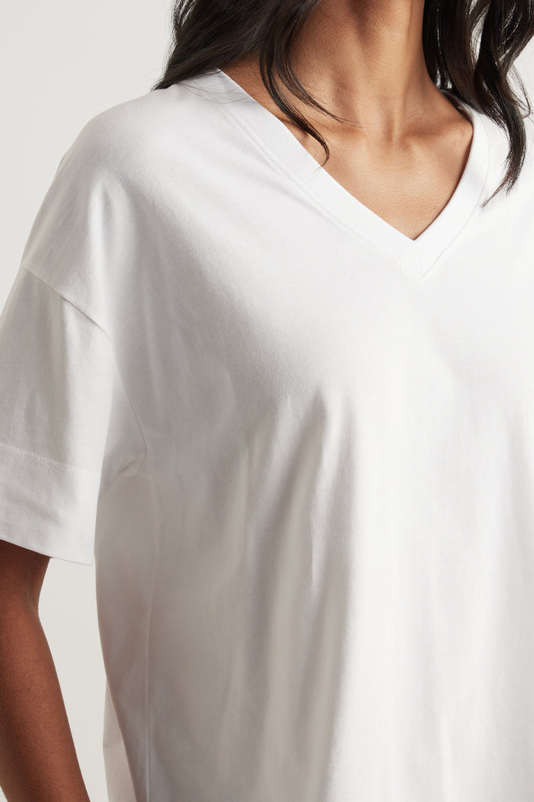 Woman wearing a relaxed white boxy V-neck tee with short sleeves