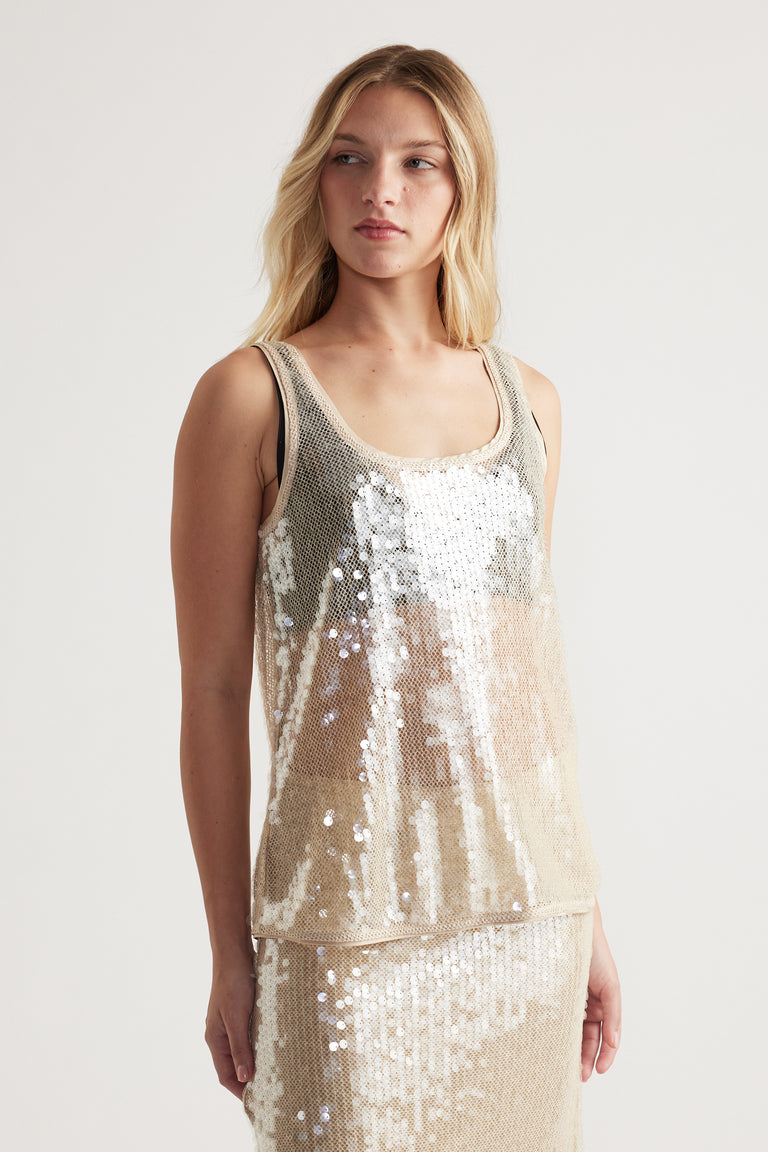 Woman wearing a shimmering sequin tank top with a relaxed fit, styled for chic and effortless glamour.