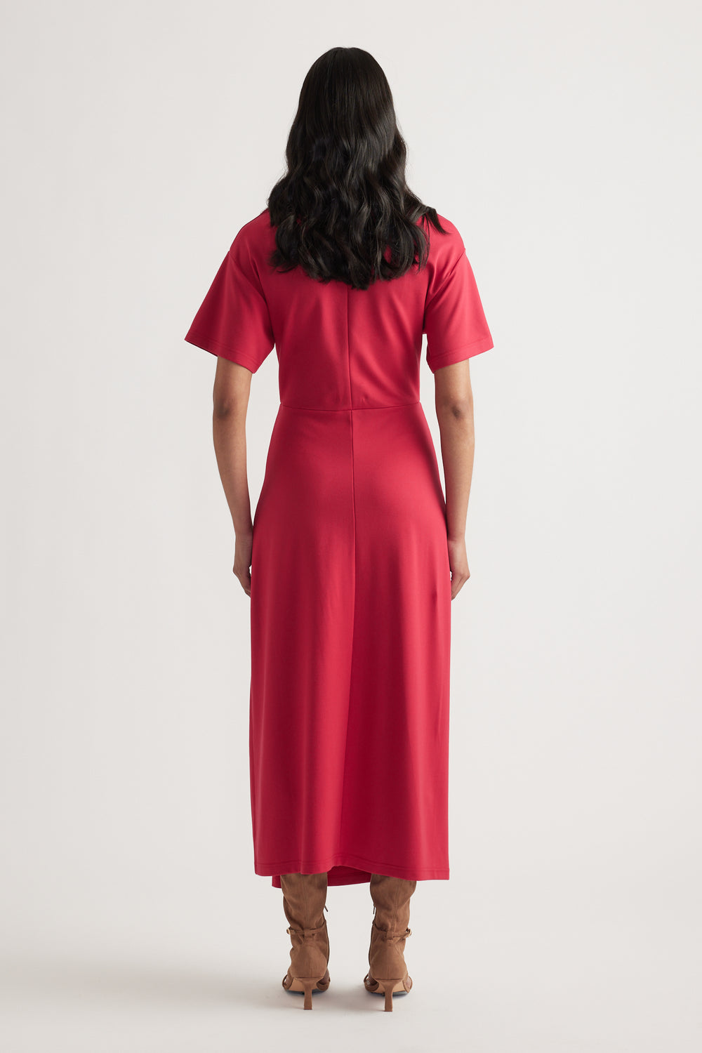 Back view of woman wearing a red short sleeve midi dress with fitted waist and flowing A line skirt