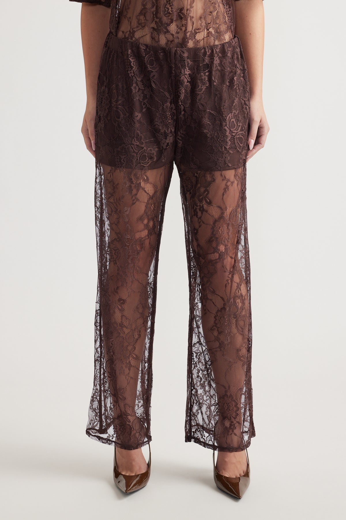 Wide-leg high-rise lace pants with detachable lining and floral pattern worn with brown pointed heels