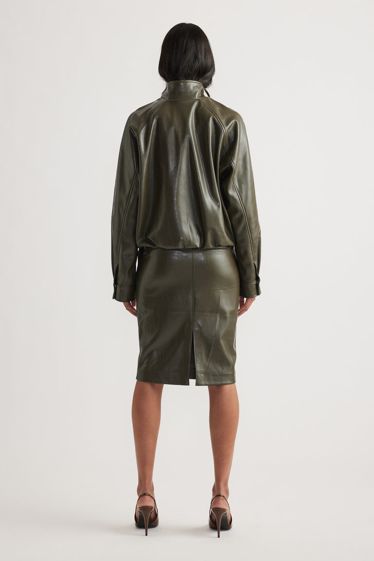 Woman wearing an olive green faux leather bomber jacket with a matching pencil skirt and strappy heels viewed from behind