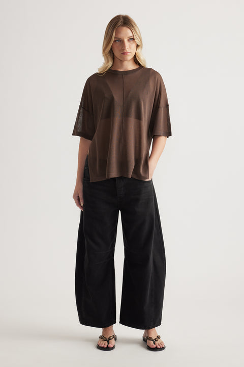Woman wearing a relaxed brown sheer knit tee with black wide leg pants and strappy sandals