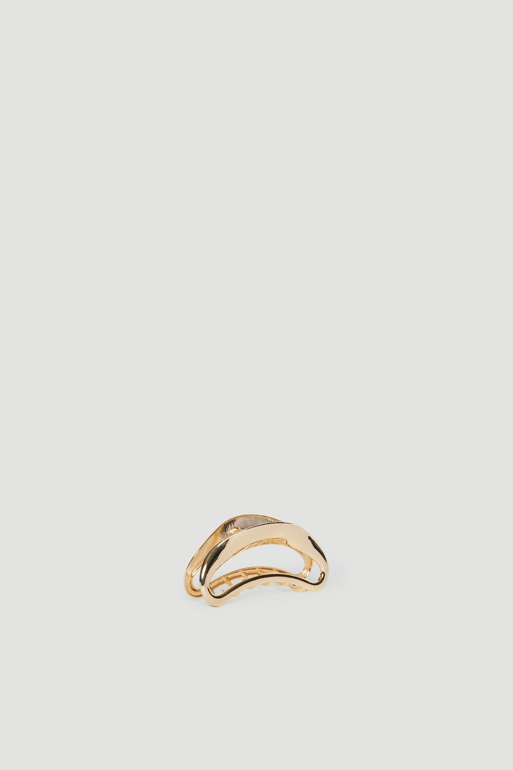 Shiny gold hair claw with smooth curved edges, designed for stylish and practical hair styling.
