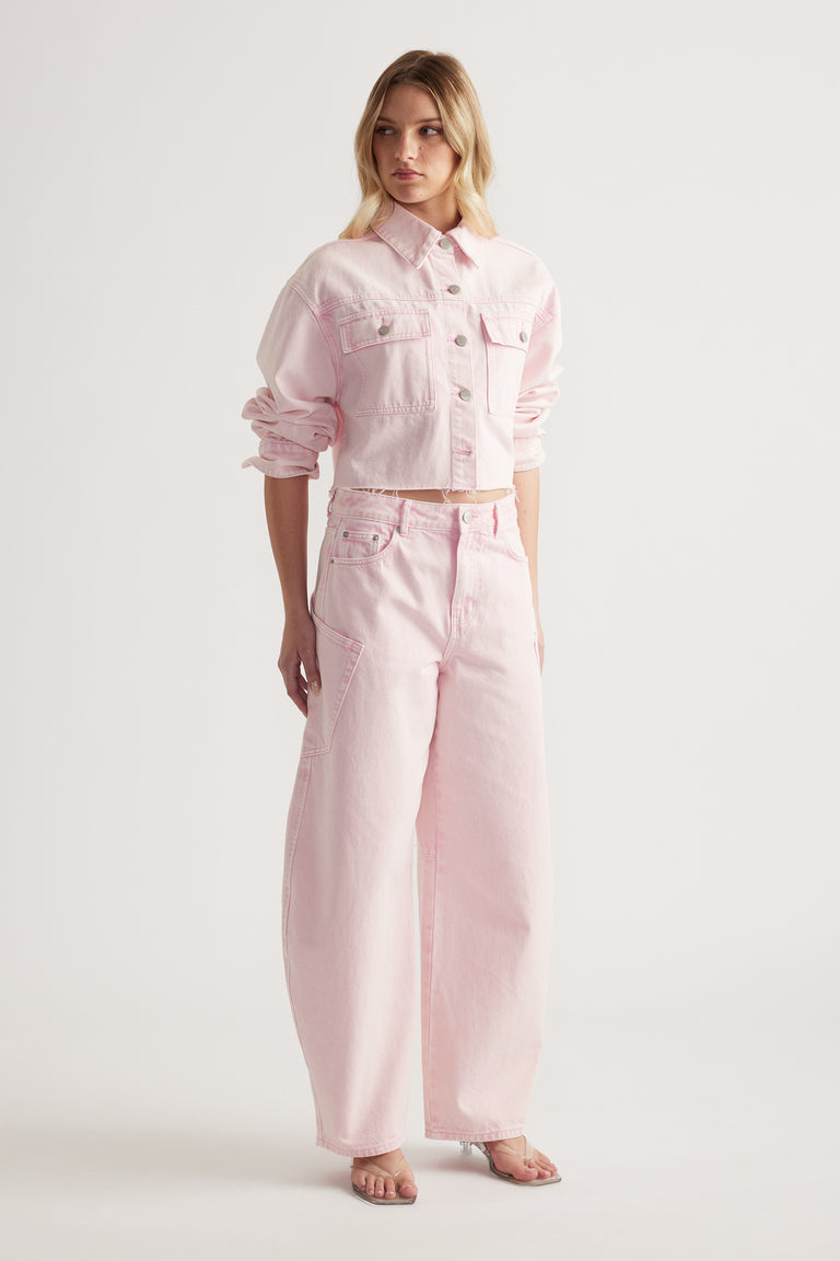 Woman wearing a cropped pink denim jacket with matching barrel leg cargo jeans and sandals