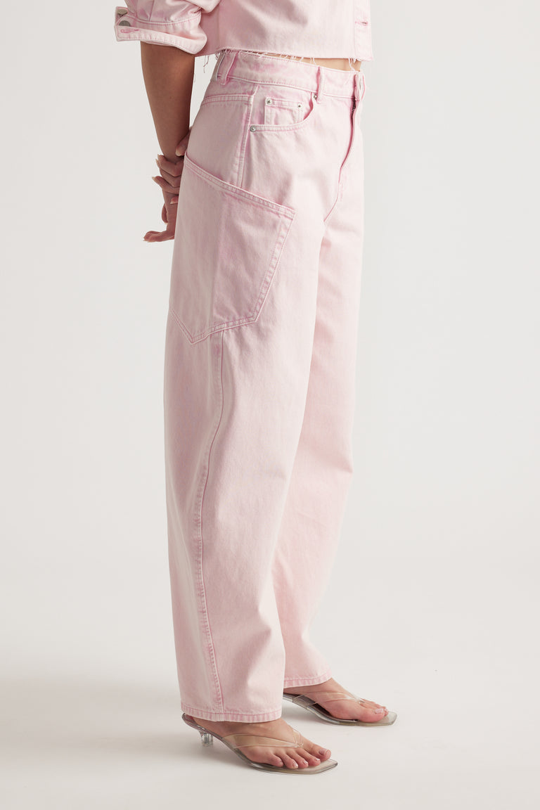 Woman wearing pink cargo barrel jeans with oversized pockets and flat sandals