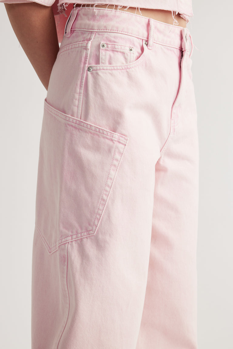 Model wearing pink cargo barrel jeans with oversized utility pockets and tapered legs