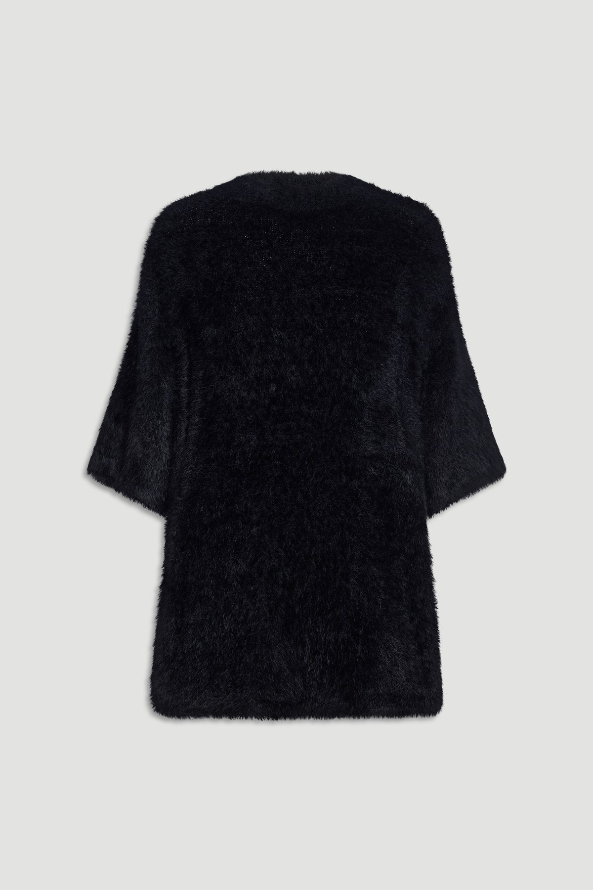 Back view of a soft black oversized knit tee with wide sleeves and a relaxed, cozy fit