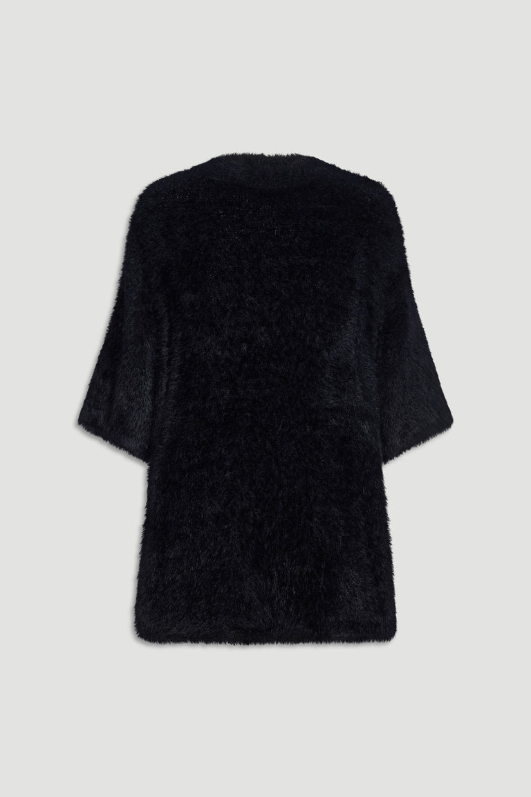 Back view of a soft black oversized knit tee with wide sleeves and a relaxed, cozy fit