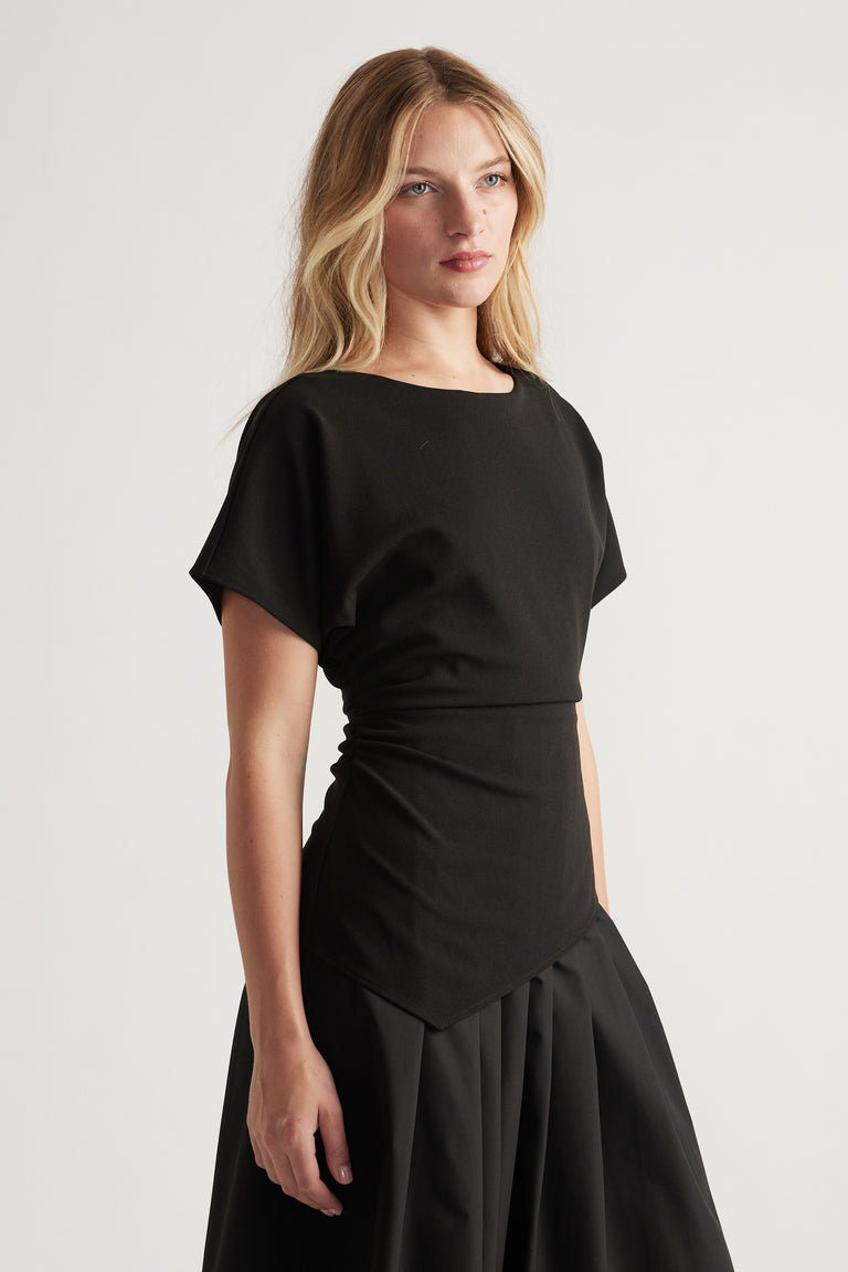Woman wearing a black midi dress with a fitted waist and structured skirt, styled for modern everyday elegance
