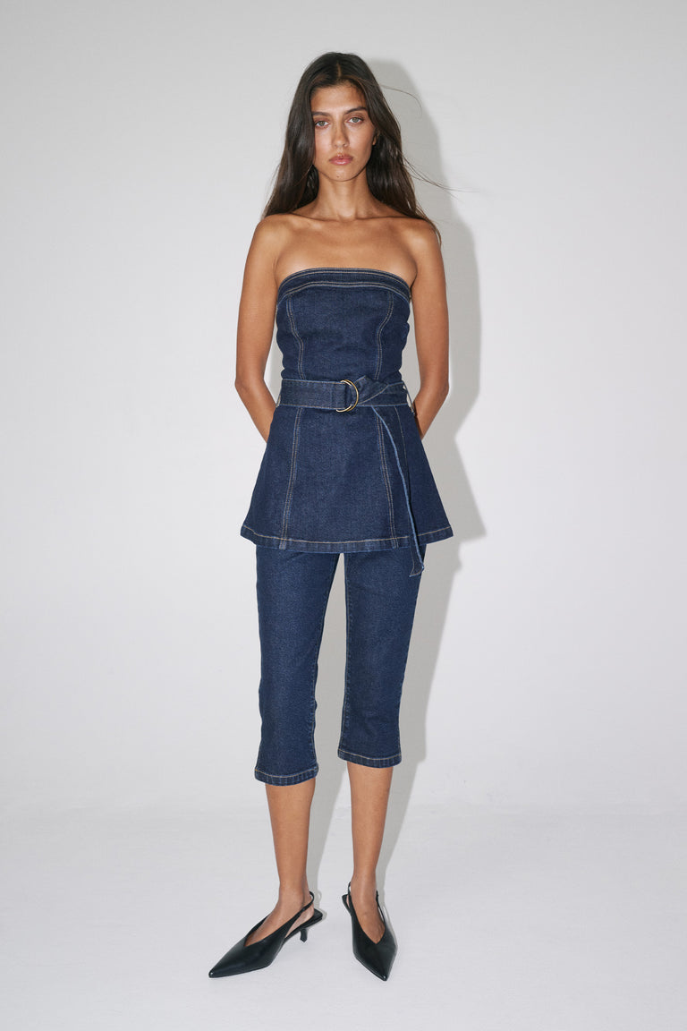 Woman in a strapless denim peplum top with matching high rise capri jeans and pointed heels