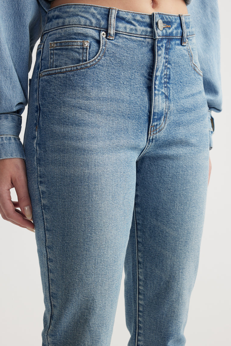 Close-up of a woman wearing high-rise light blue slim-fit denim capri pants