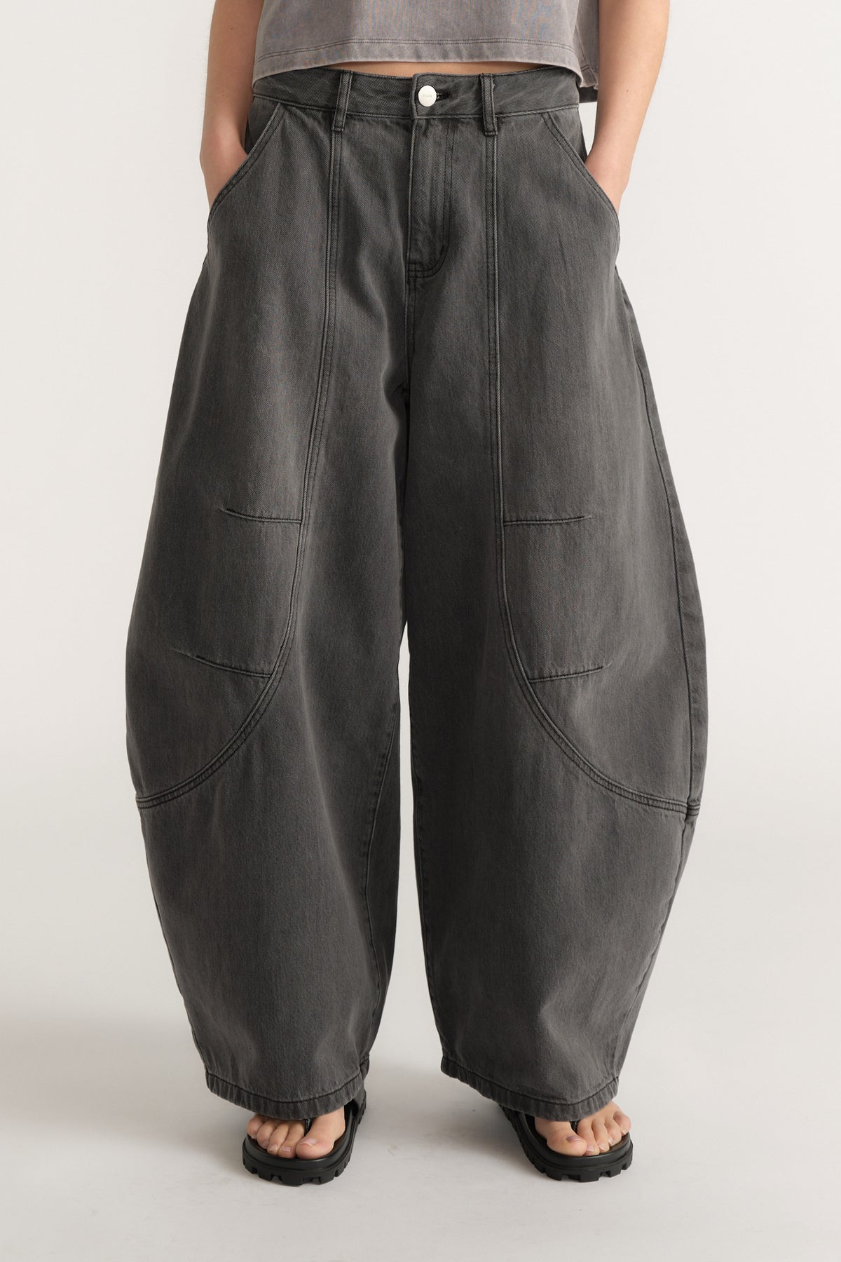 High-waisted wide-leg charcoal denim jeans with front seam details and subtle faded wash on model against plain background