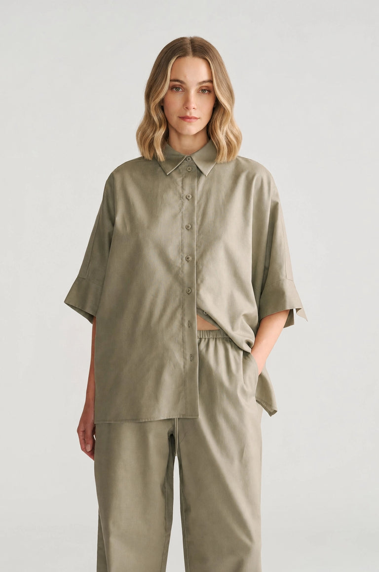 Woman wearing a relaxed fit sage oversized shirt with short sleeves paired with matching loose pants for a casual look