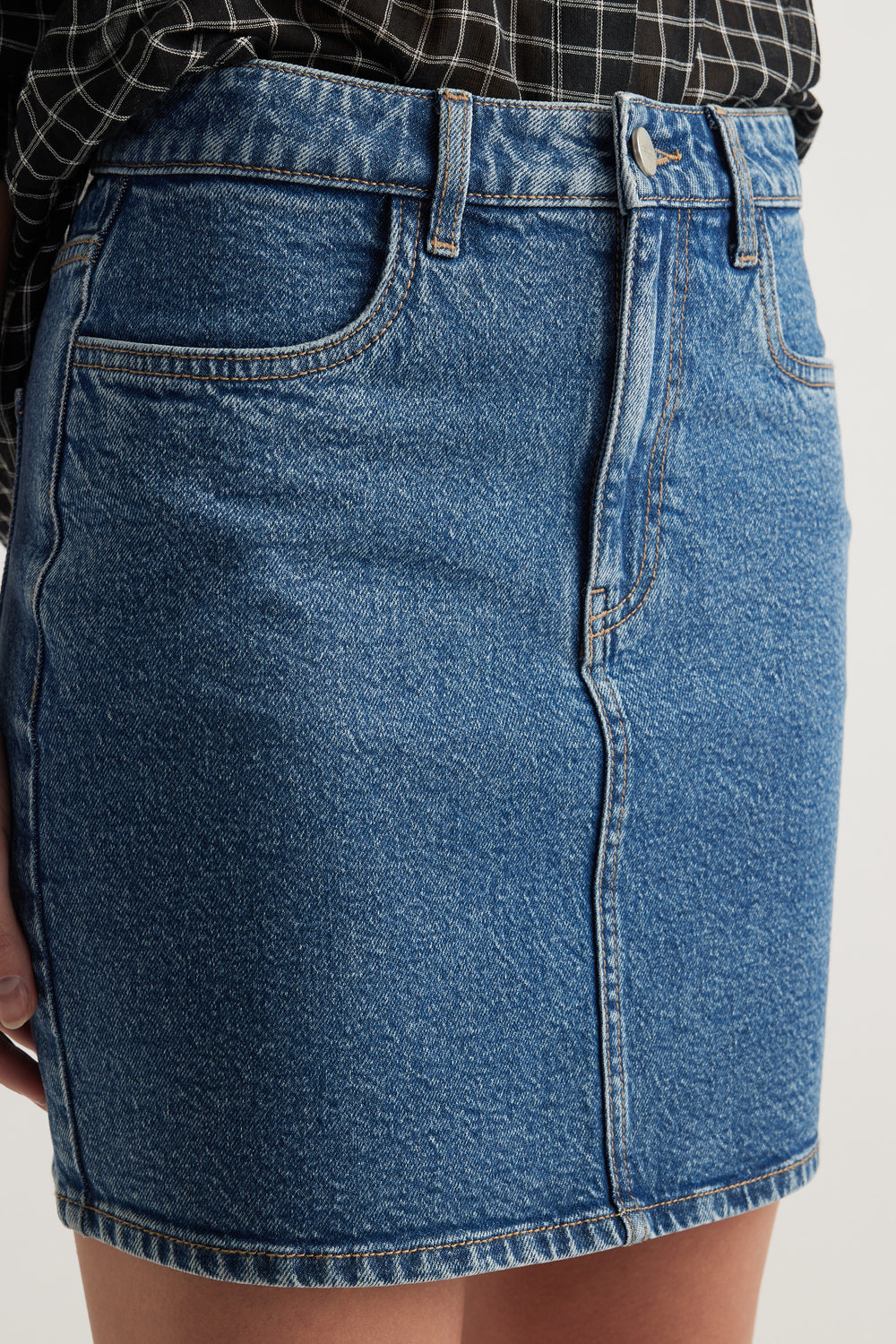 Blue high rise denim mini skirt with front pockets, belt loops and zip fly