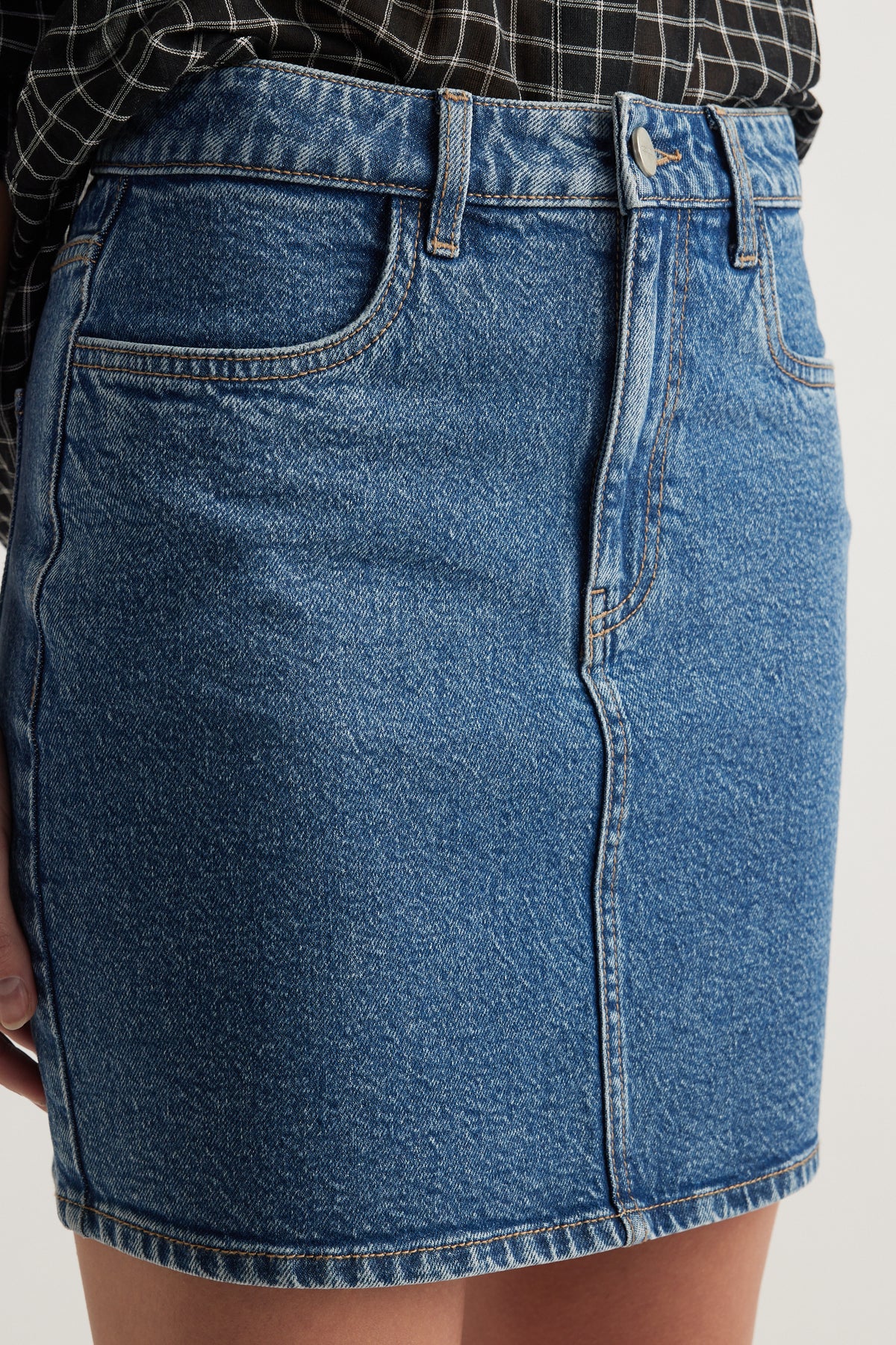 Blue high rise denim mini skirt with front pockets, belt loops and zip fly