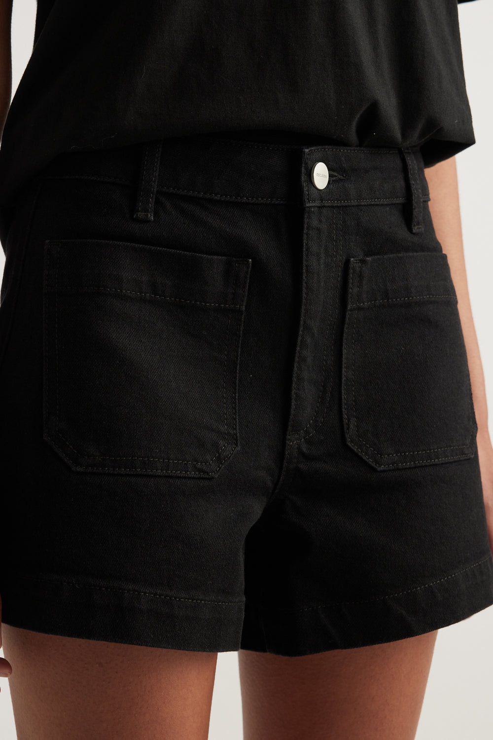 Black high rise denim shorts with front patch pockets and zip fly closure