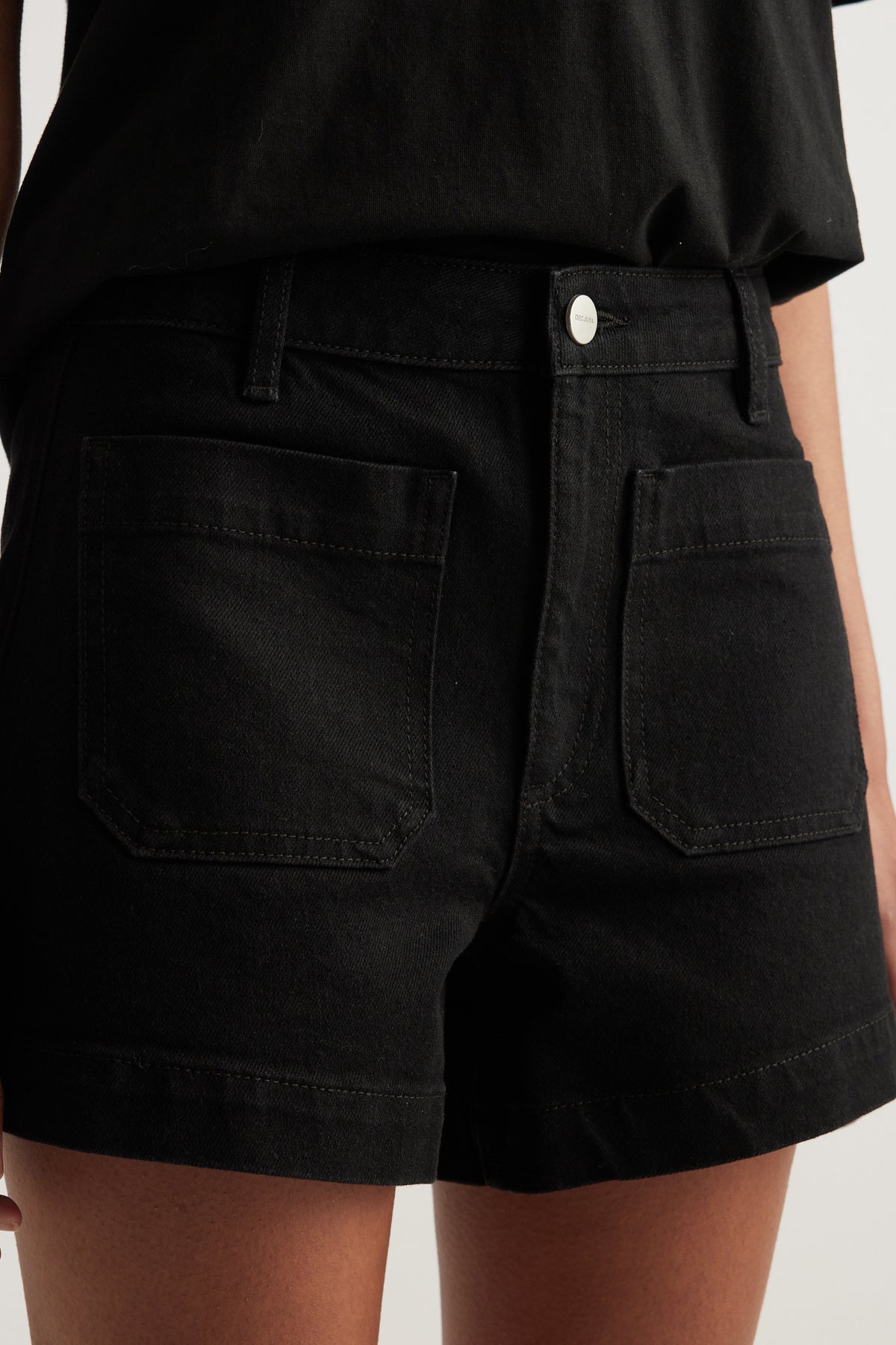 Black high rise denim shorts with front patch pockets and zip fly closure