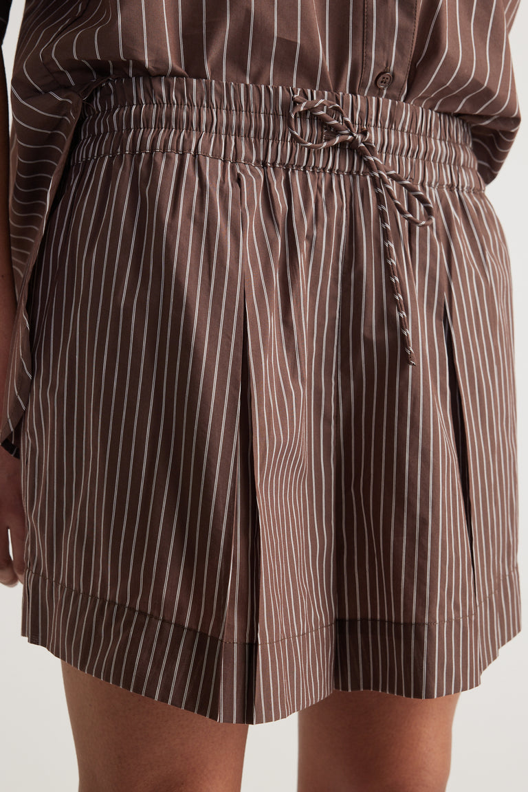 Woman wearing brown striped shorts with an elastic drawcord waist and wide legs
