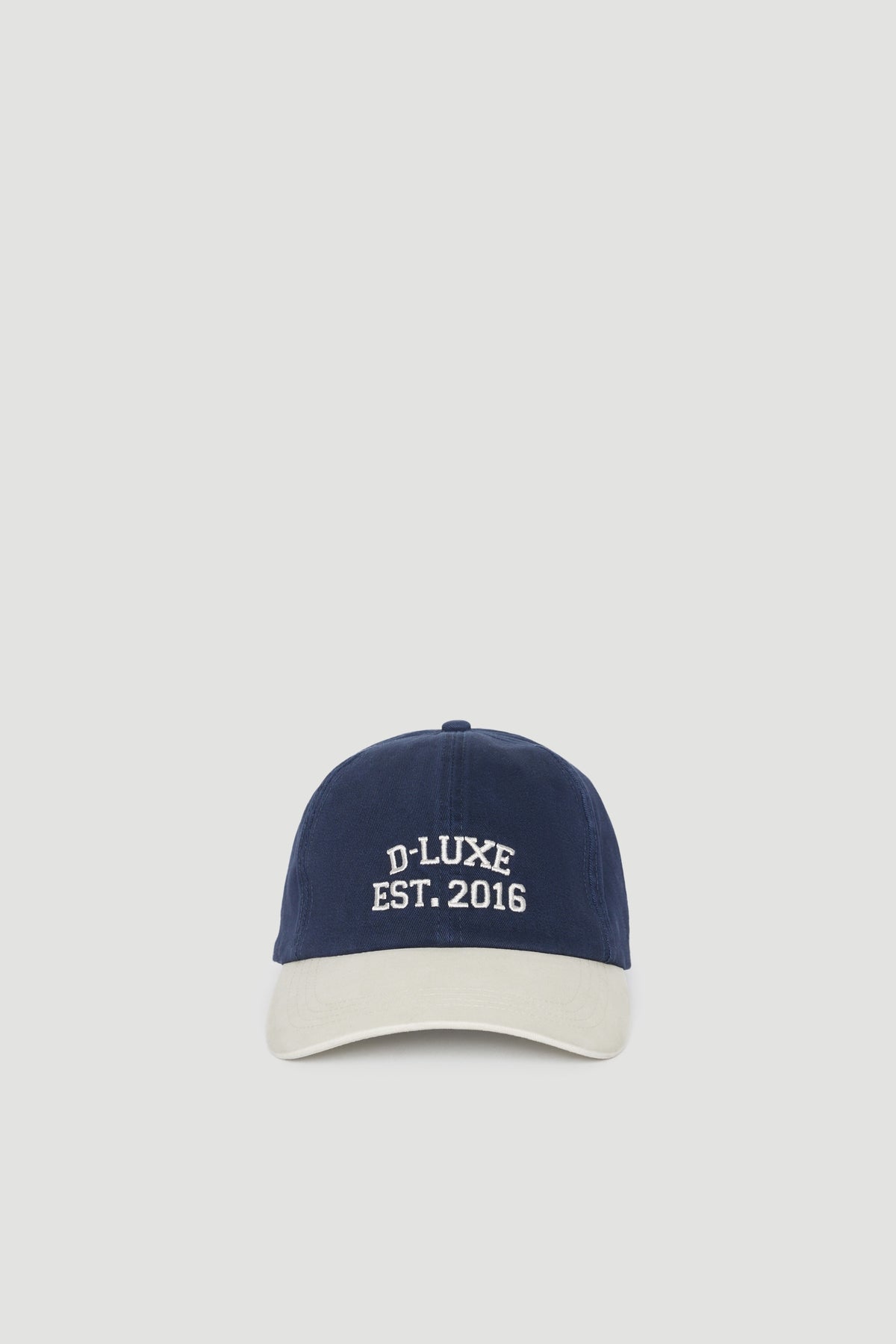 Navy blue and beige baseball cap with embroidered logo and adjustable strap for a casual, stylish look