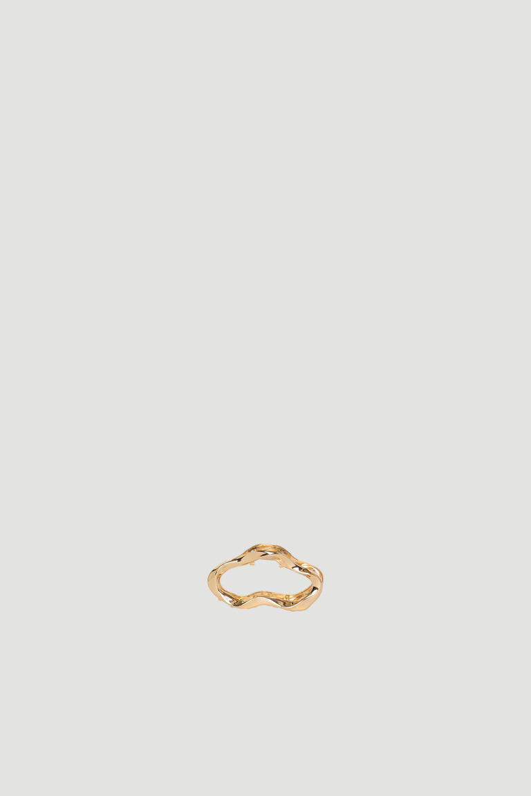 Small gold wavy hair claw clip on a neutral background