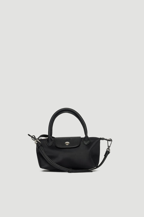 Compact black mini crossbody bag with removable strap, top handles, and silver-toned hardware closure on plain background