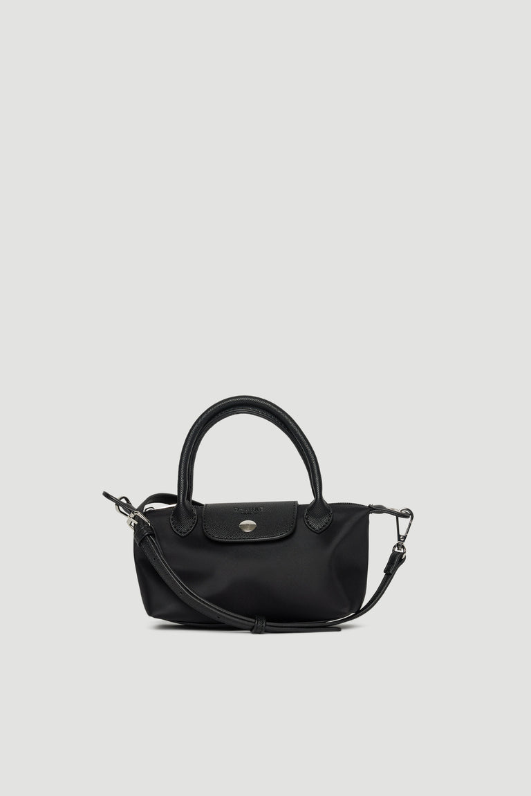 Compact black mini crossbody bag with removable strap, top handles, and silver-toned hardware closure on plain background