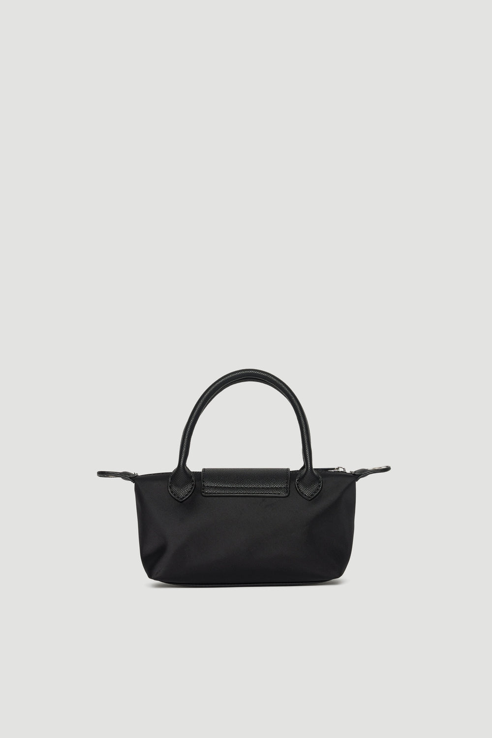Black mini crossbody bag with top handles, silver hardware, and zip closure on plain light background